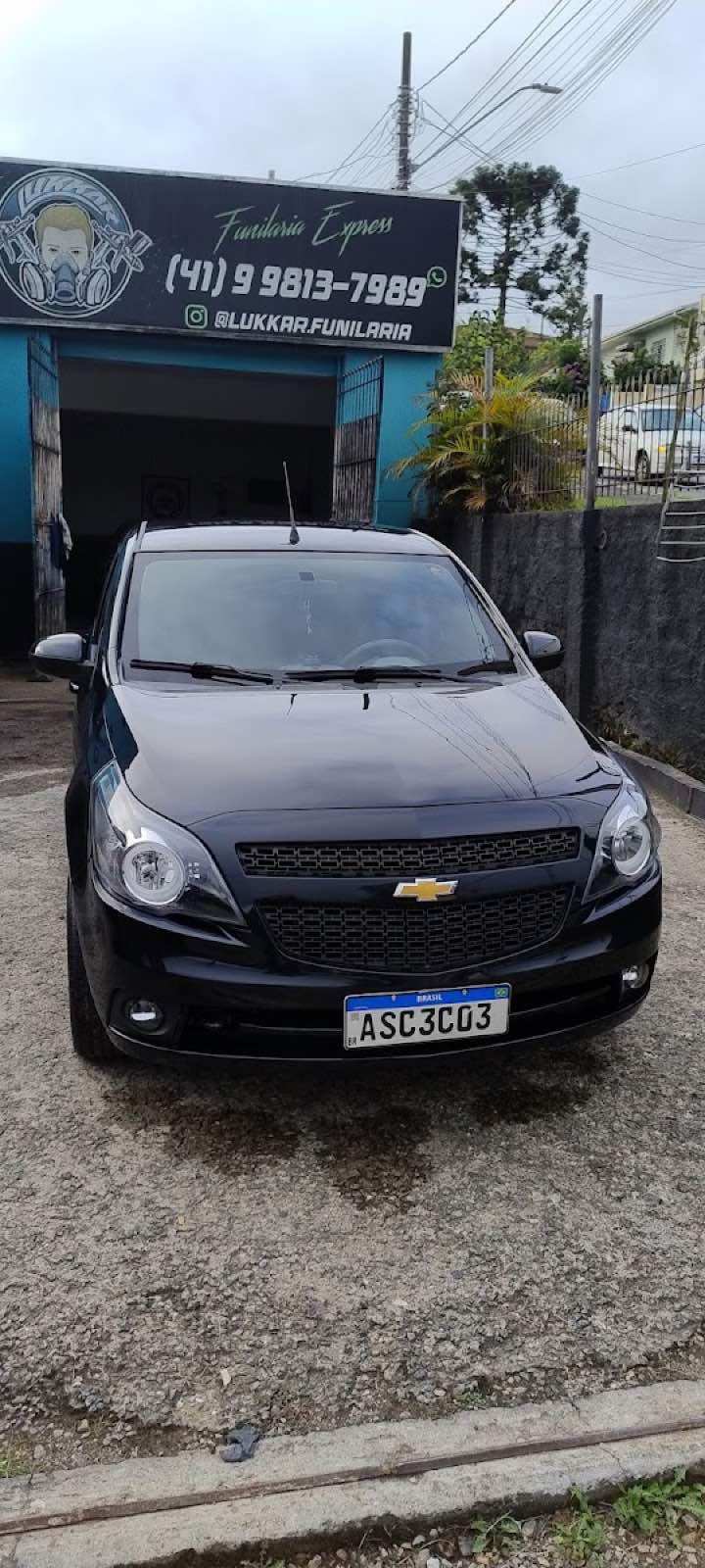 Carro atendido na fachada da LUKKAR funilaria express, com letreiro e telefone visíveis